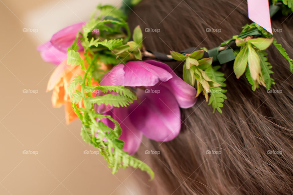 Closeup detail of flower crown garland on long brown hair conceptual photography 