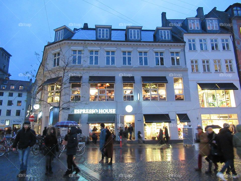 Copenhagen shopping centre with lighting reflecting on the pavement at dusk