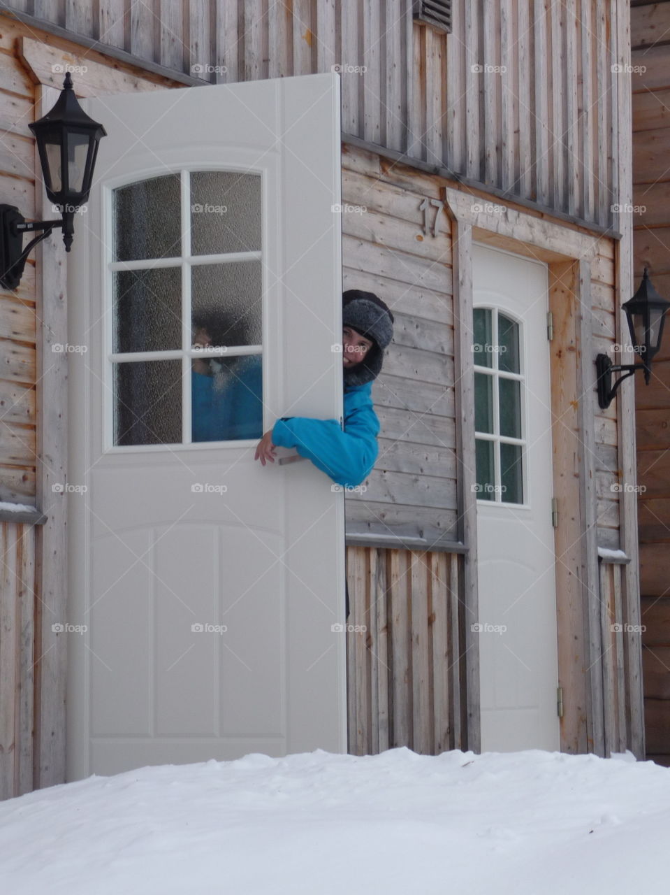 Woman peeking through door of her house