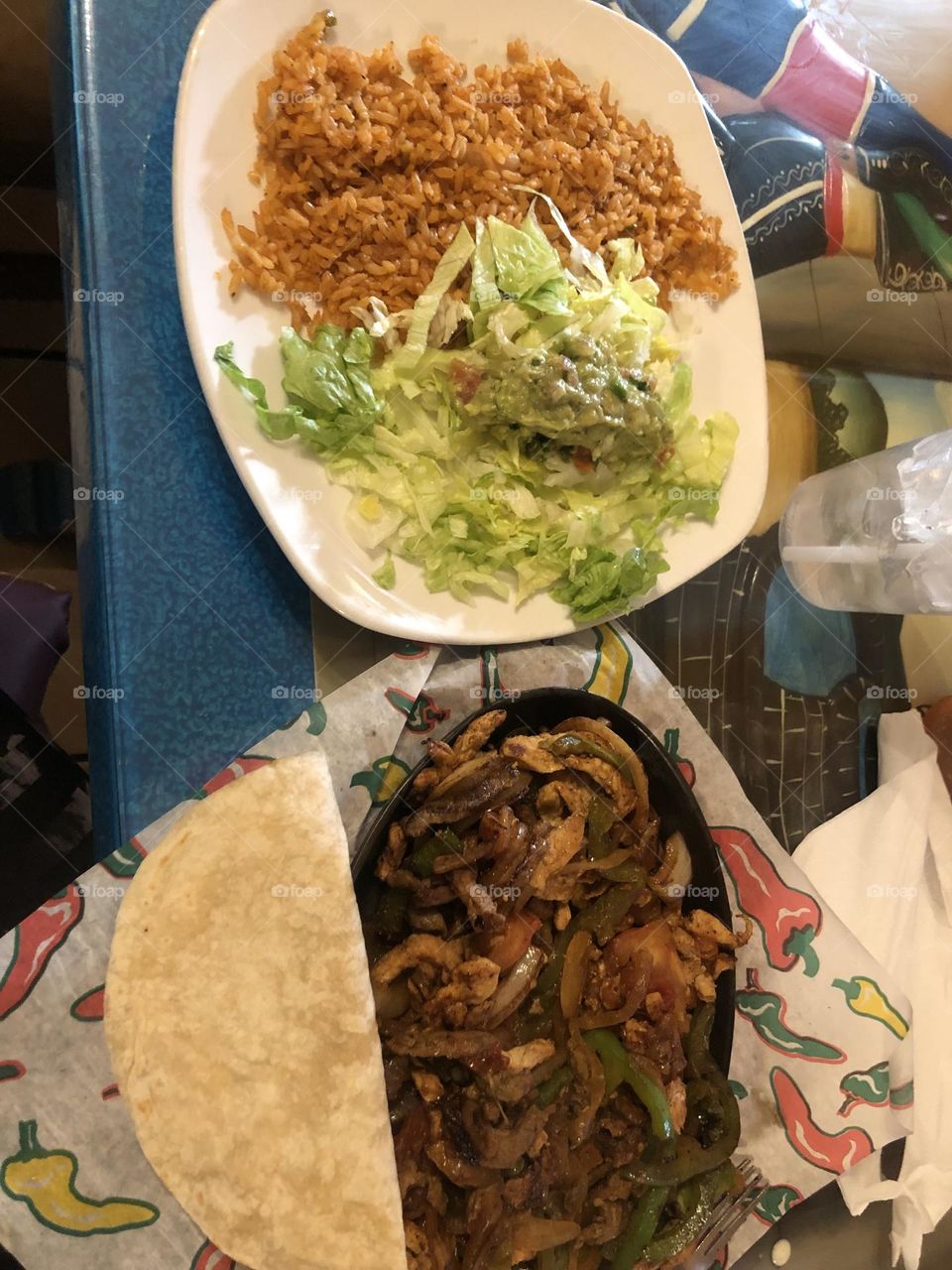 Mexican restaurant steak and chicken fajitas rice guacamole peppers onions tortillas and all the toppings 