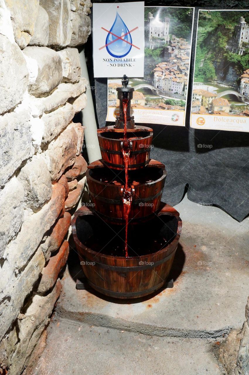  An artistic fountain filled with red colored water, a tribute to Rossese the local wine, found in the ancient village of Dolceacqua, Italy.