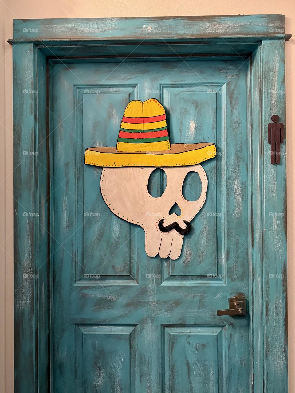 Yellow hat on the teal door