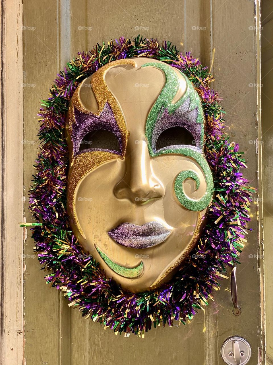 A brightly colored Mardi Gras mask on a door