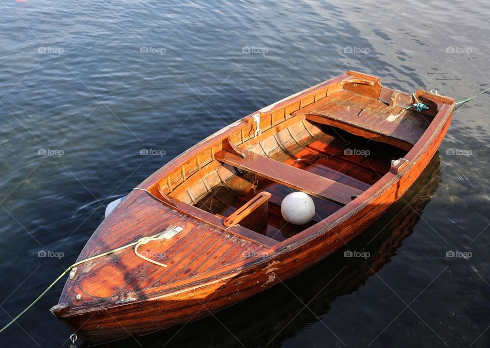 Boat in water. Wooden boat laying in the harbor