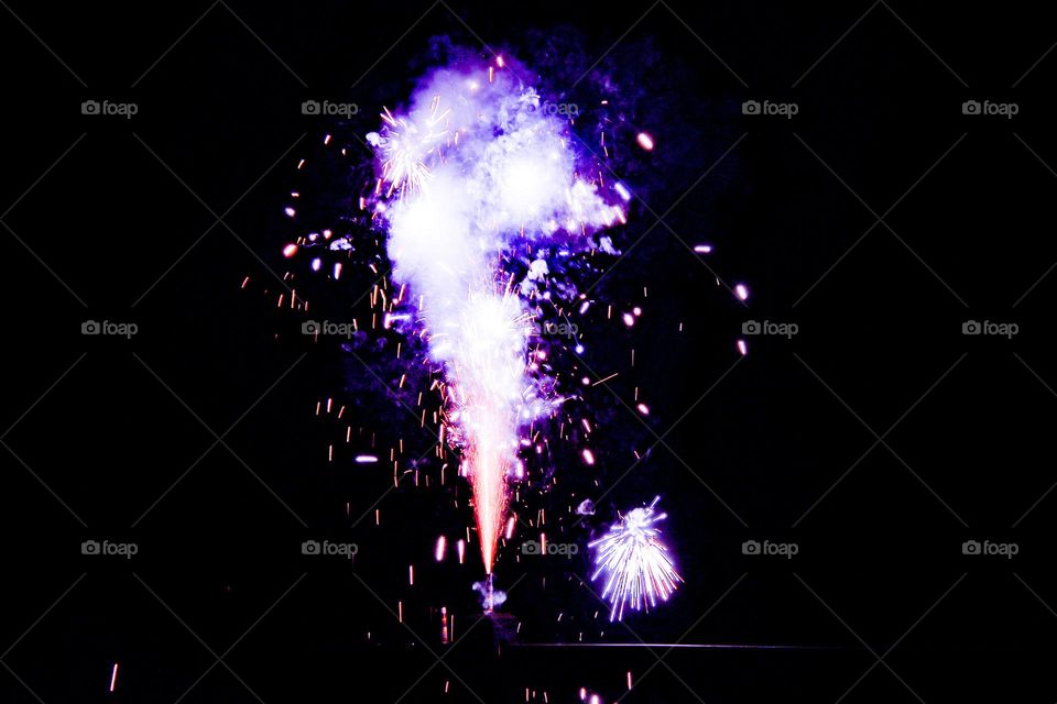 purple fire cracker exploding in the night sky