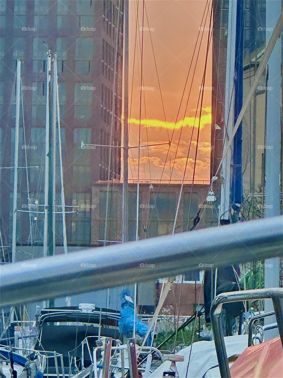 Sunsets at “Newtown Creek” by the “Pulaski Bridge” in LIC, Queens can be spectacular such as this gleaming orange red glowing sensation glaring at us from between two newly built LIC high rises. 2024. Hypnotic Productions