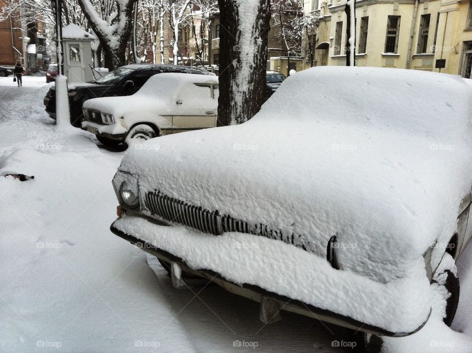 Snow-capped soviet car on winter street. gaz-24 
