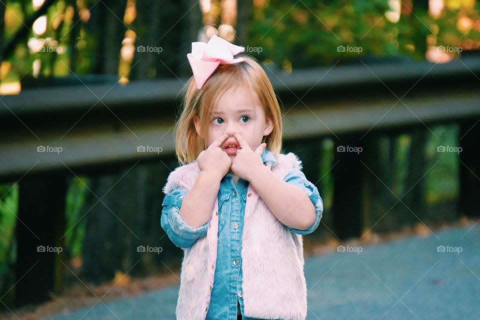 Cute girl with finger in nose