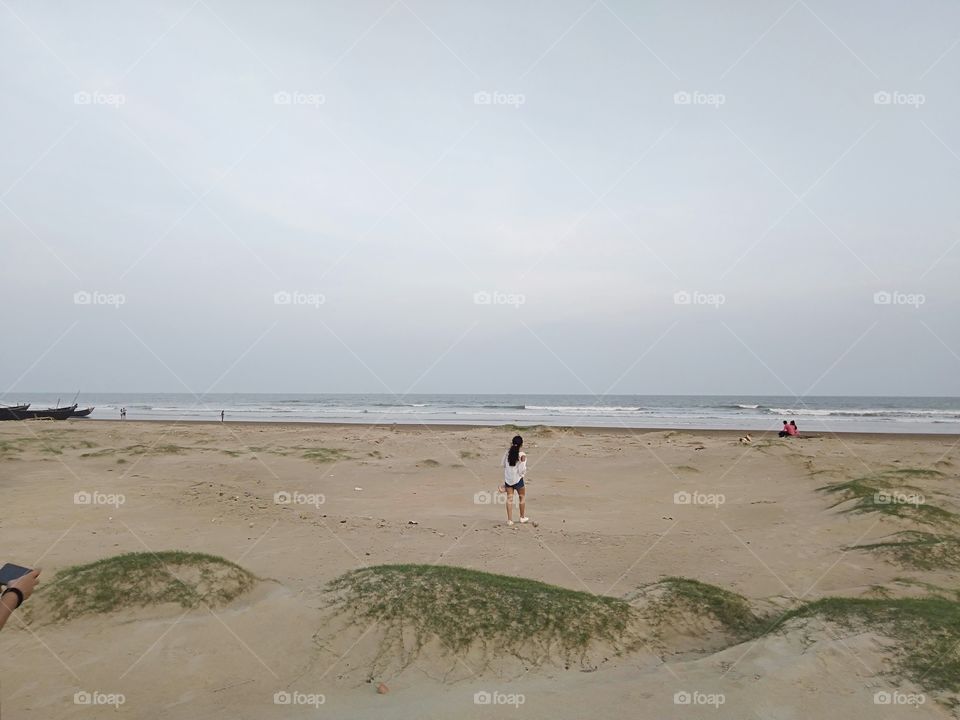 Girl walking on beach at sunrise