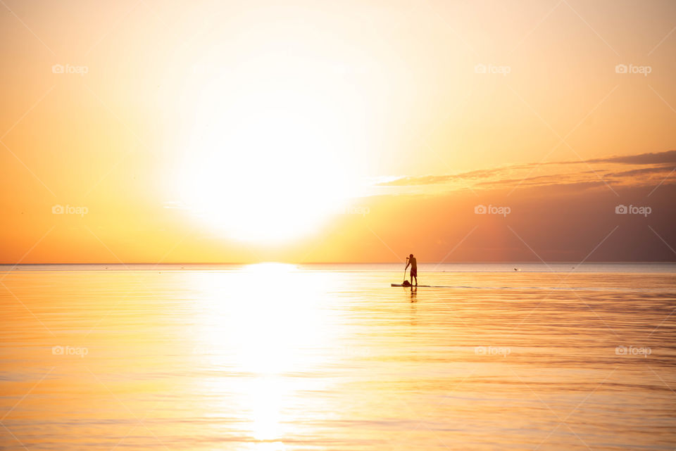 mad paddle boarding into bright sun