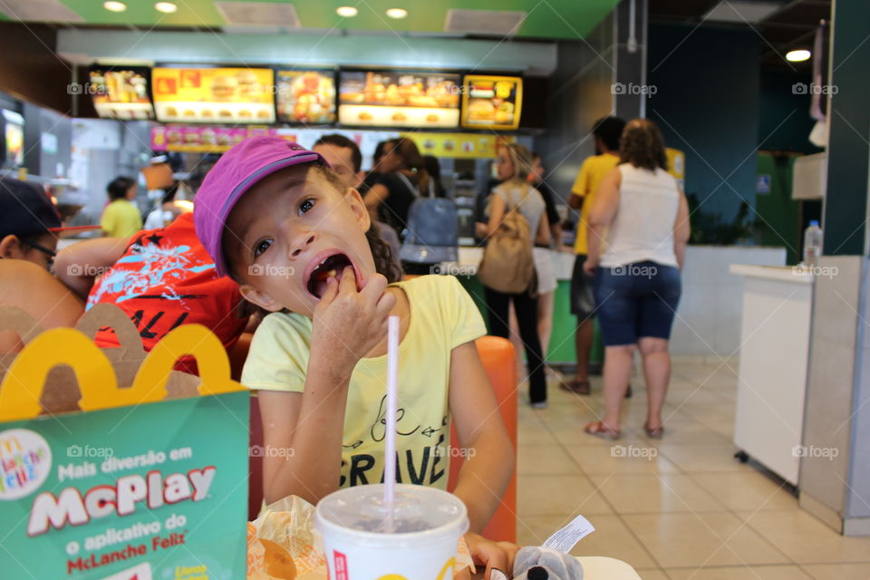 little happy girl eating at McDonald's