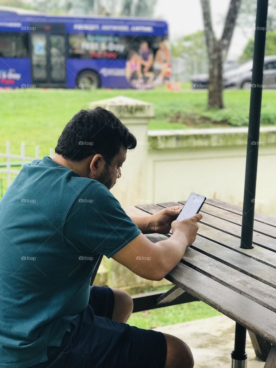 Person seeing phone by sitting on outdoor table 