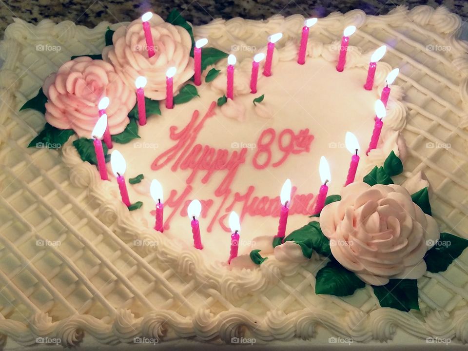 89th birthday cake with pink candles and pink and white roses