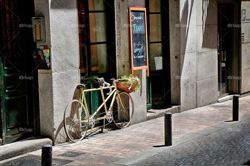 On the street. Street cafe inviting visitors with a rare tandem bicycle parked outside