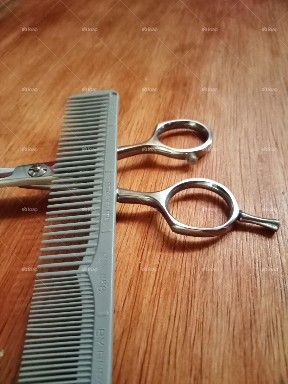 Cutting tools, comb and scissor on the table.