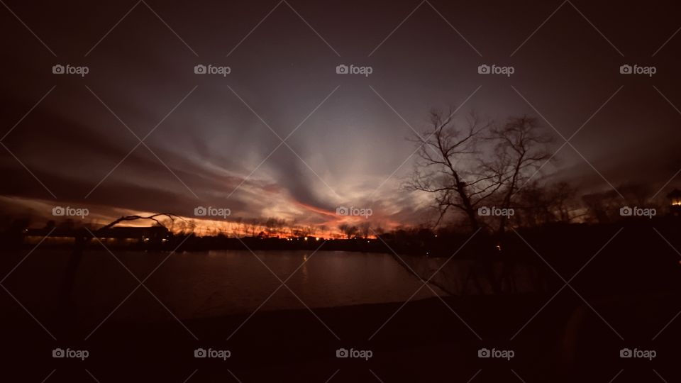 Beautiful Sunset-Twilight-Night swooping Clouds with a Greenish Tint. Backlit with enormous colors on Horizon. Reflections from Sky to Lake Waters have Colorful features.
