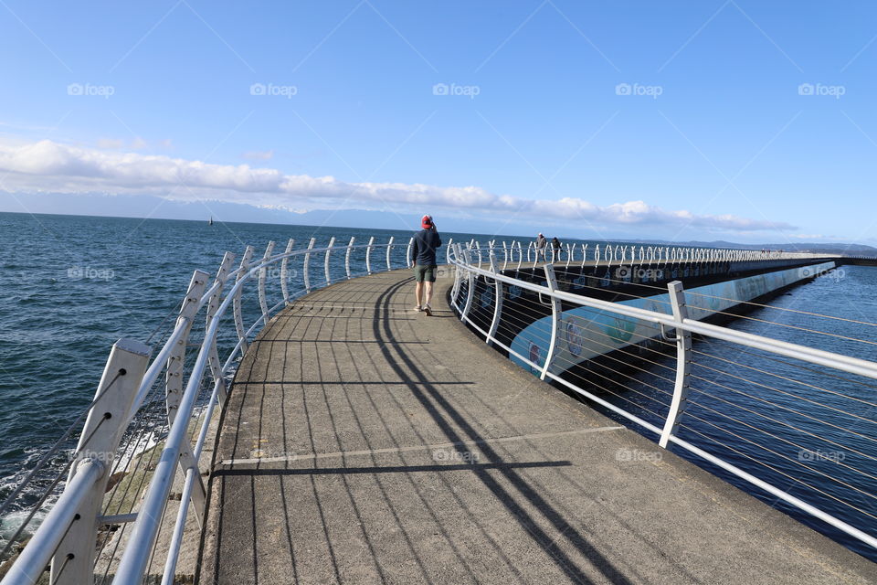 Shadow of metallic fence on breakwater 