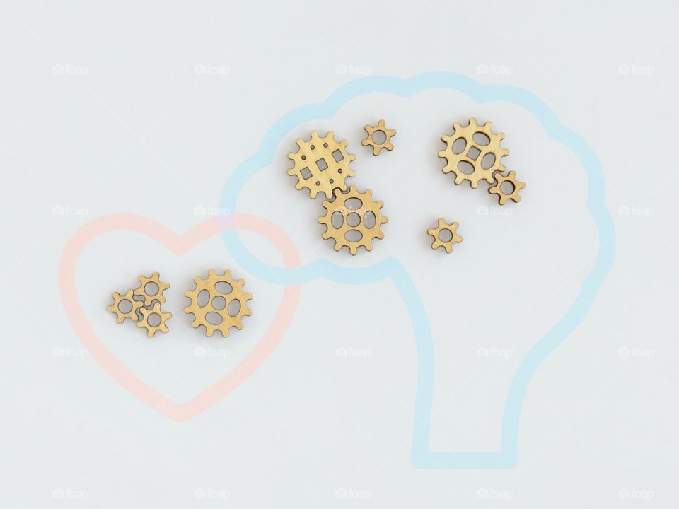 wooden gears in brain and in heart, symbol on the grey background, creative concept