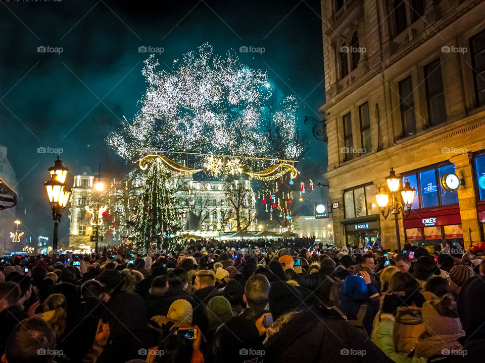 People Enjoying Holidays Taking Photos With Cellphones At New Years Eve Celebration Outdoor Crowded Party With Fireworks
