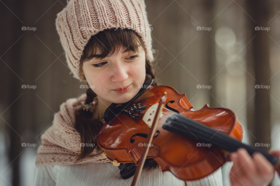 Teenage girl portrait with violin in winter park