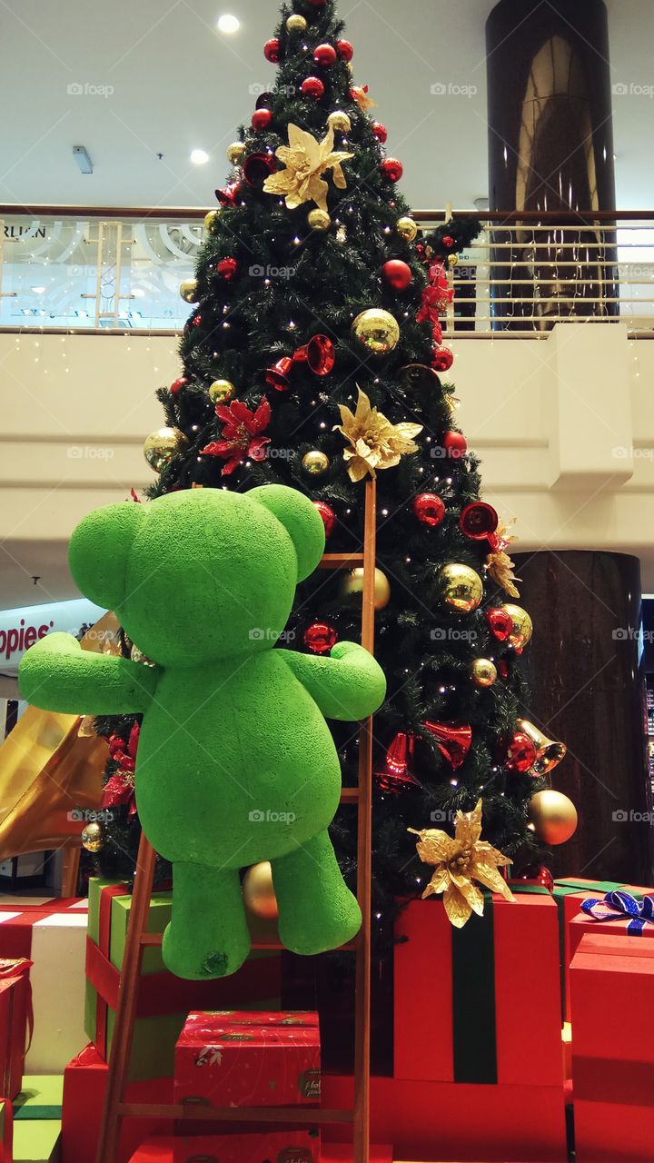 Green bear climbing Christmas tree