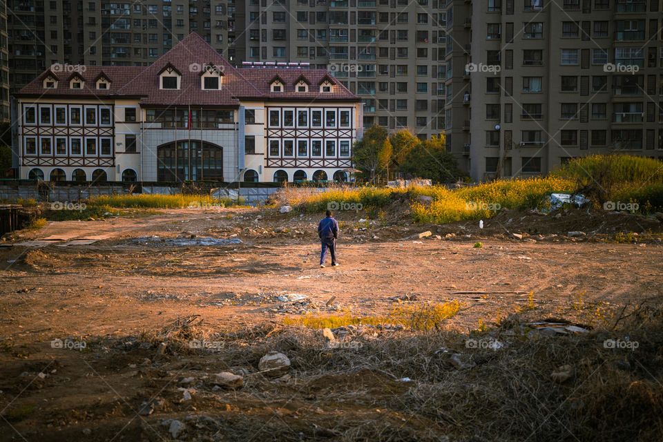 A man is walking on a ground to catch the sunlight.