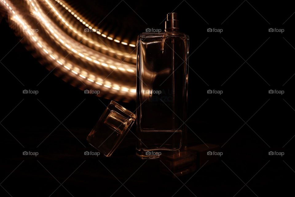 A bottle of Kenzo perfume with a string of light in the background
