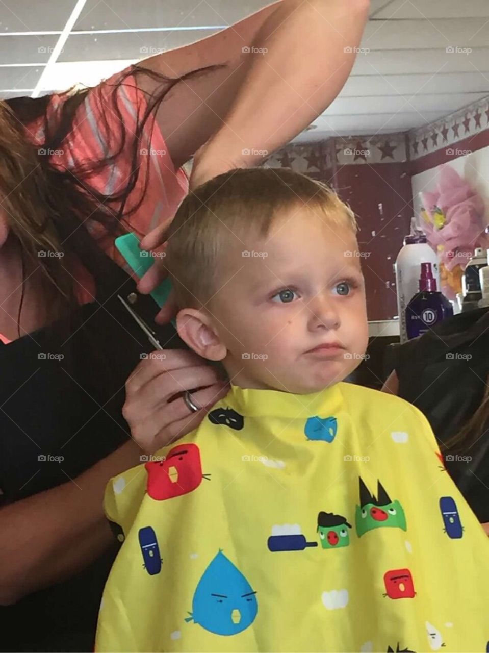 Cute little boy getting a haircut. 