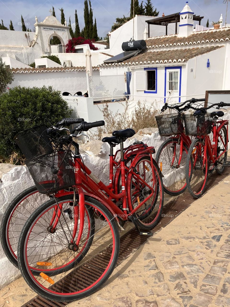 Bicycles on pavement before white houses 