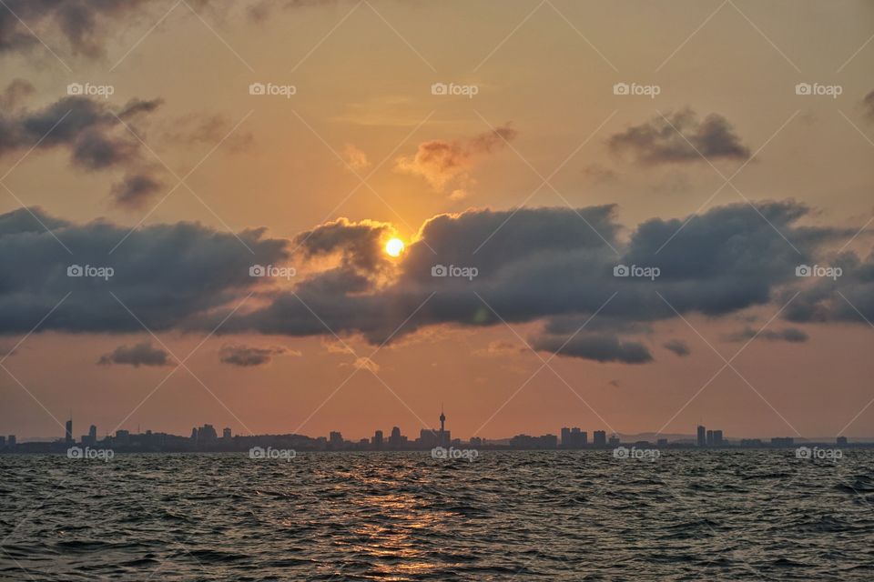 City and sea in cloudy morning sunrise. City and beauty in nature landscape.