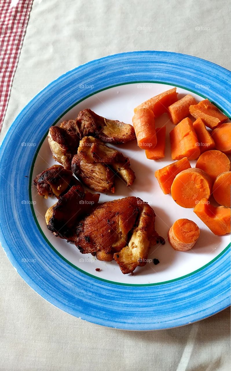 chicken with carrots in blue plate