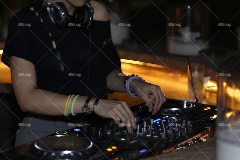 Close up on hand of a female Dj mixing music on platines