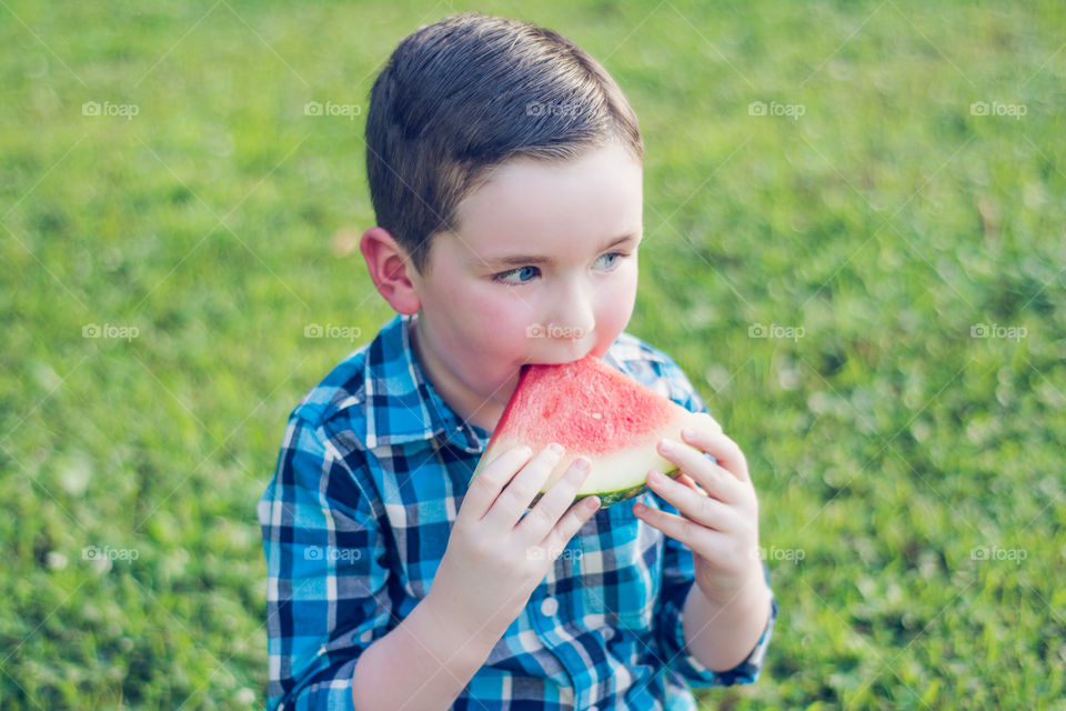 Young Boy Eating Watermelon at the Park on the Grass 2