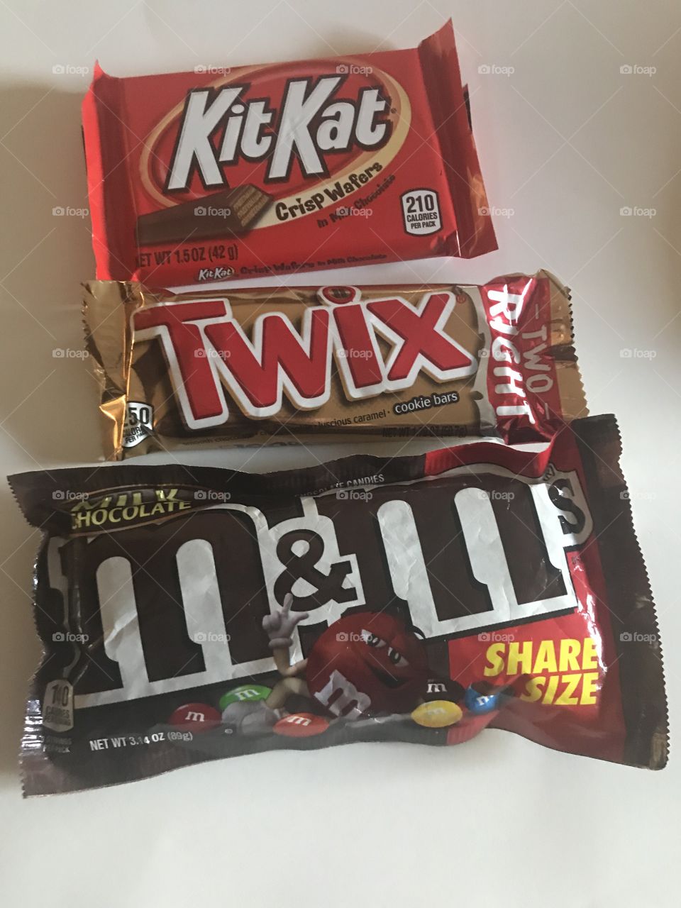 A delicious variety of chocolate candies, kit Kat bars, Twix bars, and m and m’s.