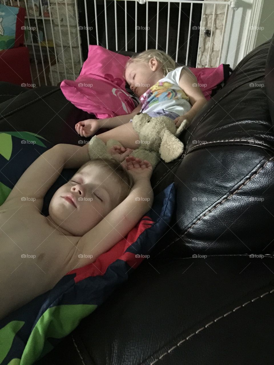 Twins napping on the couch with their toys