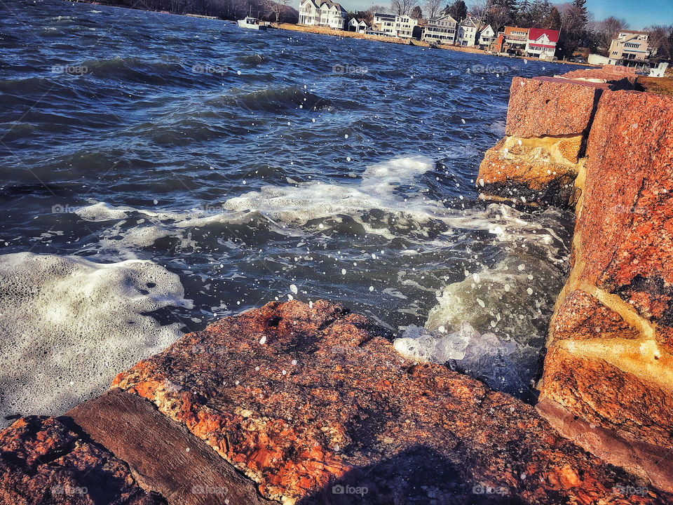 Wind and waves crashing on a harbour wall 