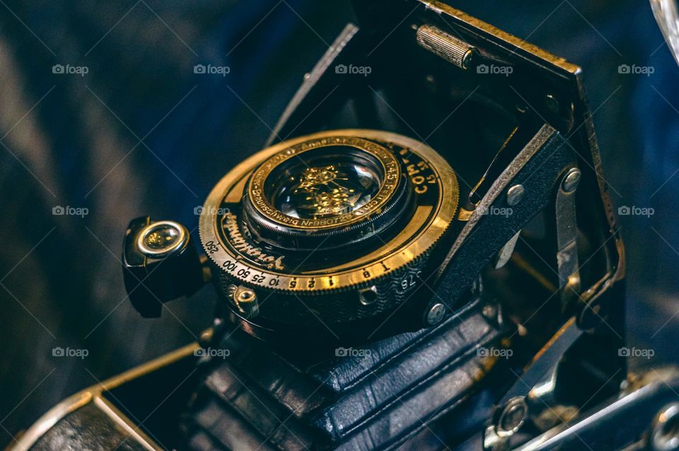 Vintage old German mechanical photo camera with manual settings of a metal focusing ring and diaphragm.