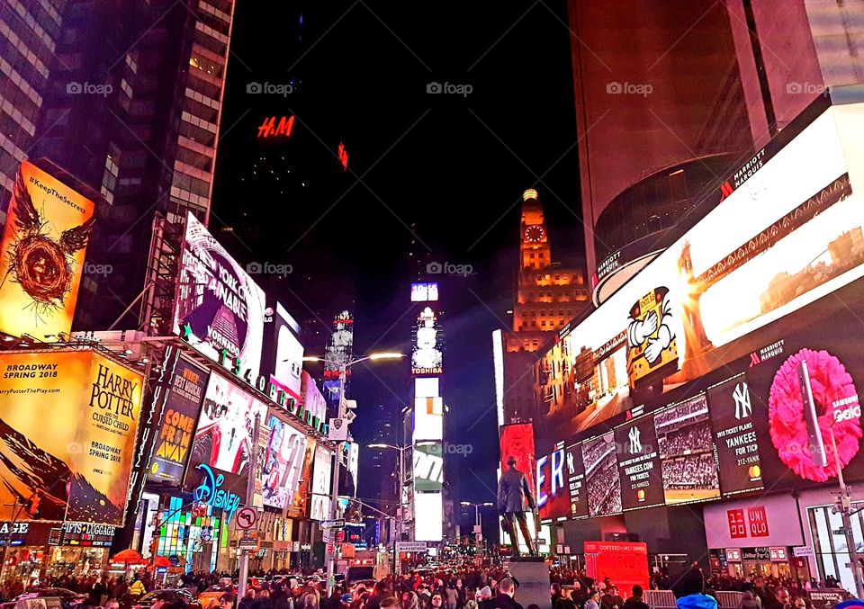 Photo of Time Square in New York on a winter's evening, busy with people and bright lights.