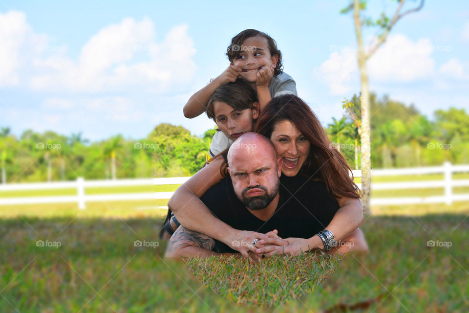 Family stacking over each other in park