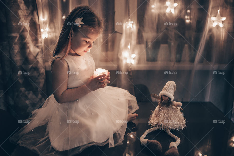 Christmas moment girl in a white dress on a background of Christmas lights