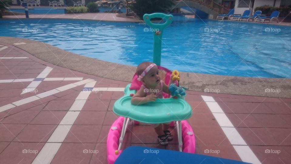 baby poolside. baby girl by swimming pool