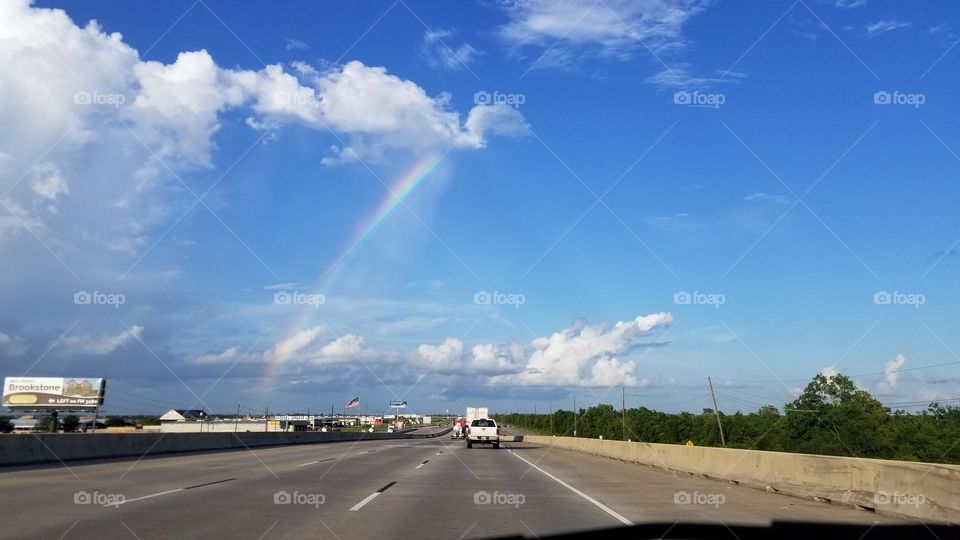 A rainbow above a highway street