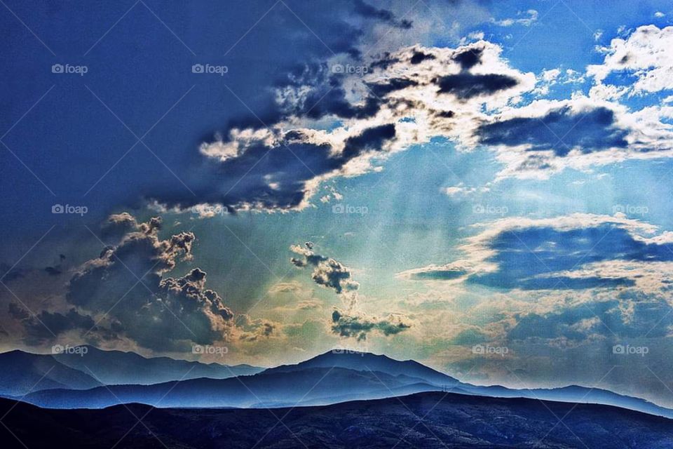 Sun rays peeking through light blue clouds!