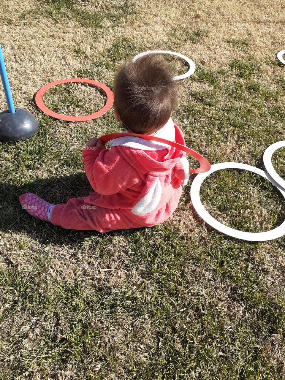 bebé jugando con aros en el pasto