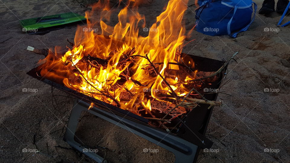 this fire, while just lit at a beach on a barbaque grill it still looks amazing with the bright orange mixed with a vibrant yellow while also having the Sandy beach floor. You can almost hear the roaring and crackling flame.