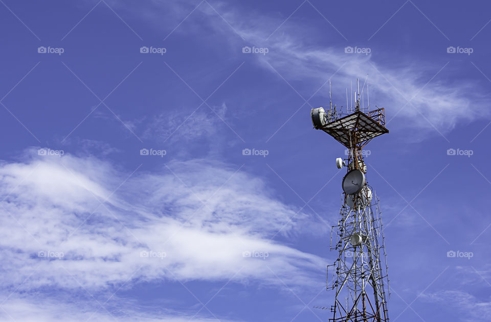 Wave transmission mast large phone signal with a bright blue sky.