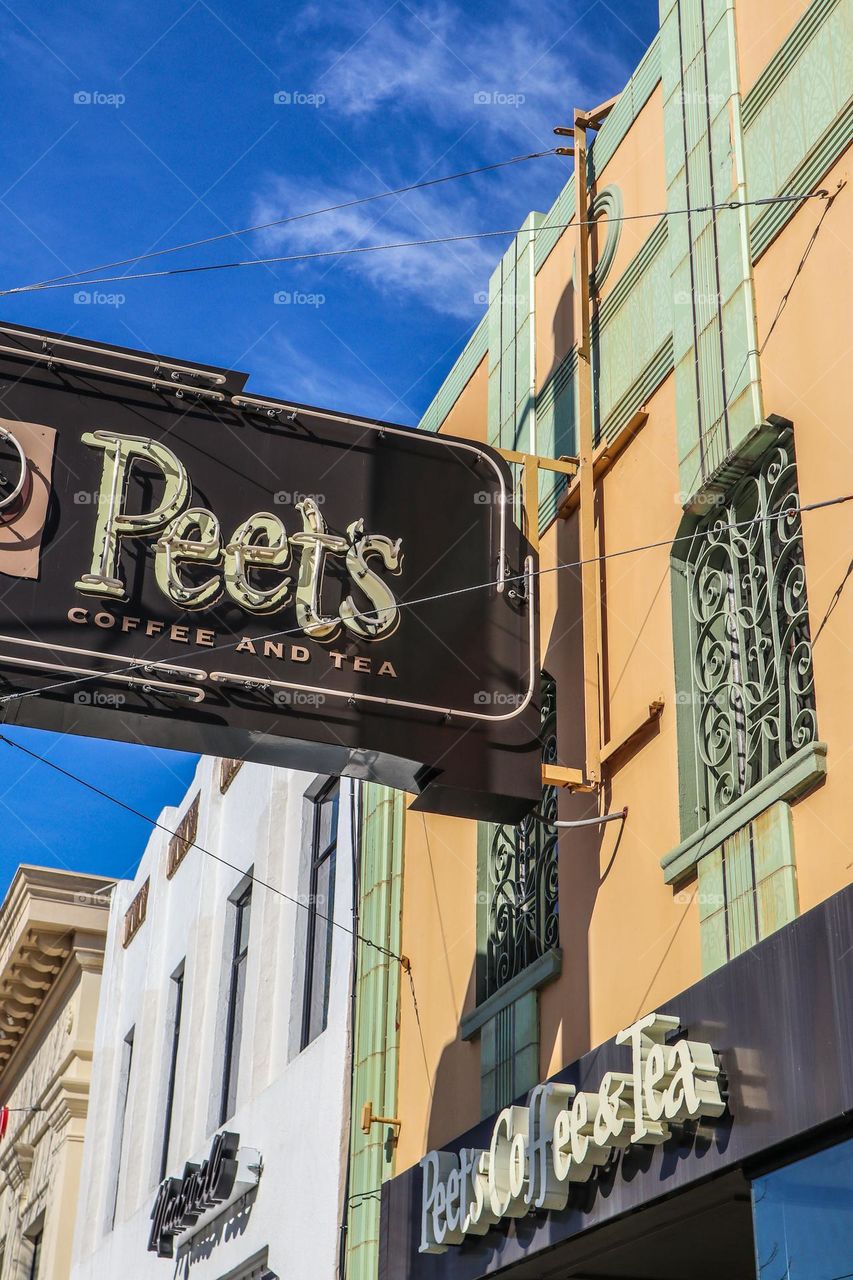 Peet’s Coffee Shop sign hanging above a coffee shop in an art deco style building 