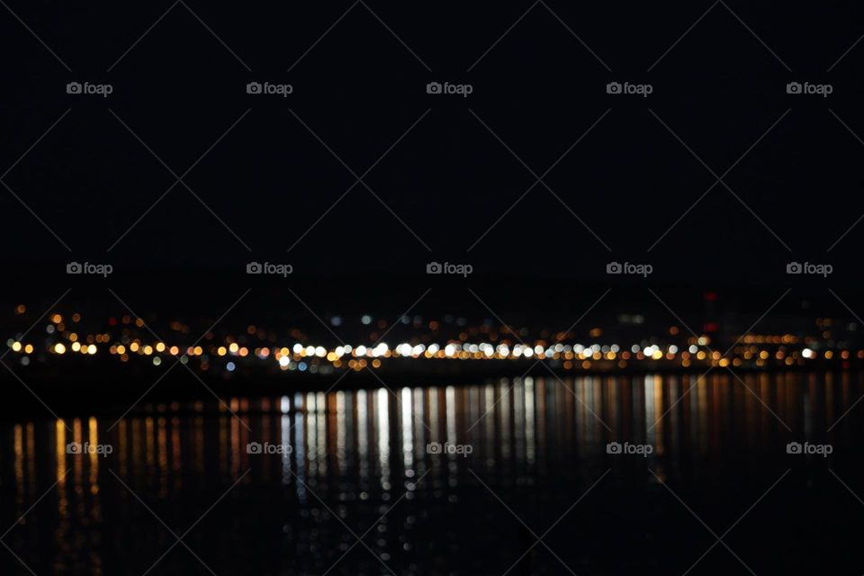 Capturando a magia da noite na cidade! As luzes dançando na água do rio Tejo criam um reflexo incrível. Aqui, a agitação da cidade é capturada em sua essência desfocada, mas ainda brilhante.