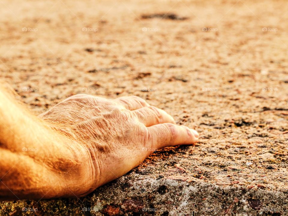 One hand outdoors on a stone surface 