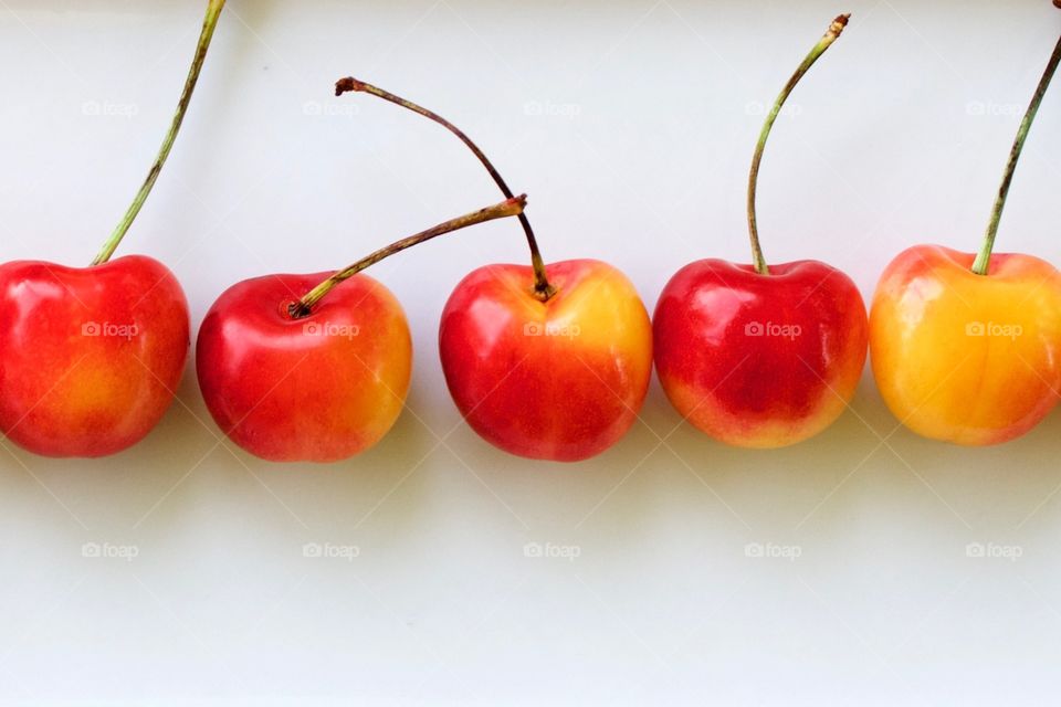 Fruits! - Closeup of Rainier cherries arranged horizontally by color gradation on a white rectangular plate in natural light
